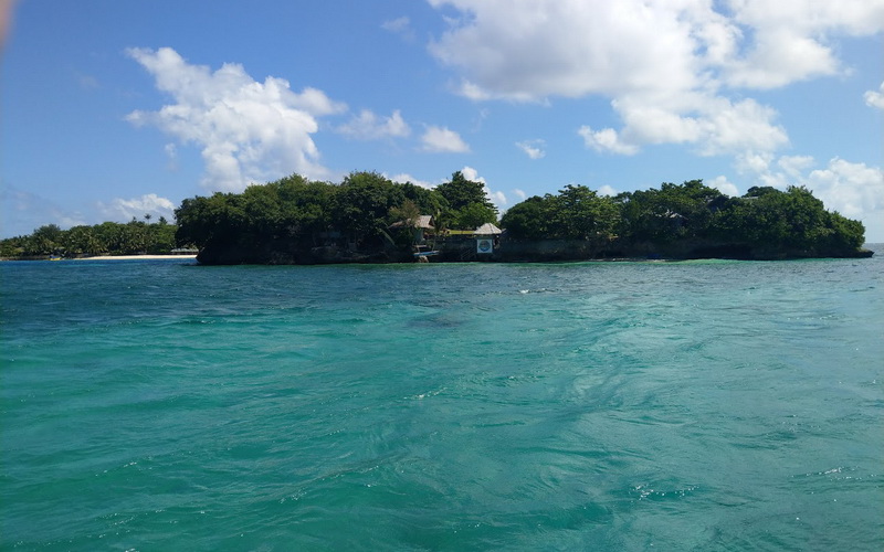 Travellers cliff jumping into turquoise water at Ariel's Point near Boracay