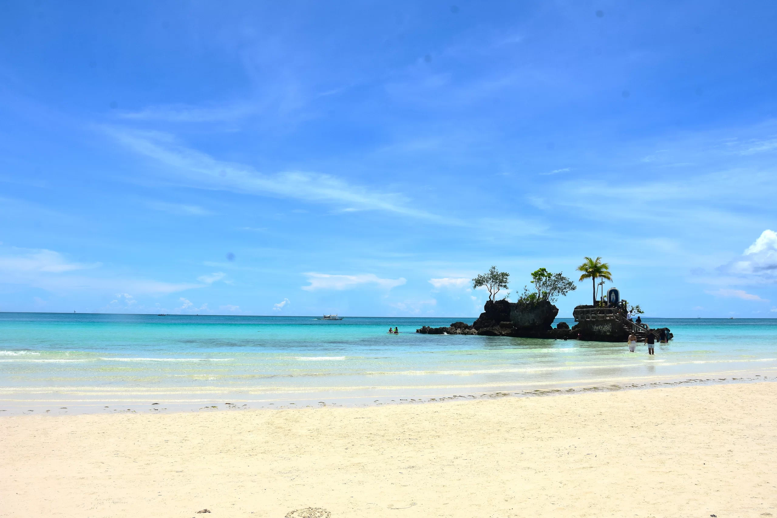 Aerial view of the full length of White Beach Boracay with turquoise water and the island behind