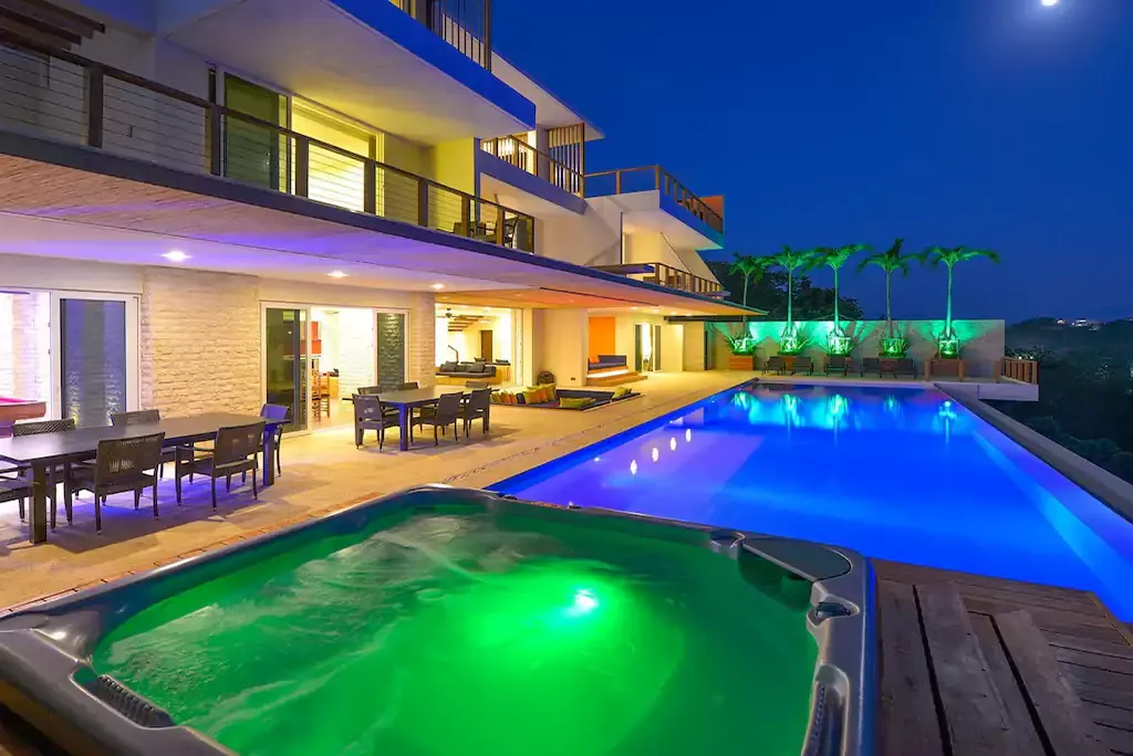 Pool, jacuzzi and outdoor dining at dusk