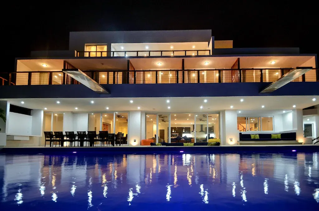 Margaretta Villa lit up at night across the pool