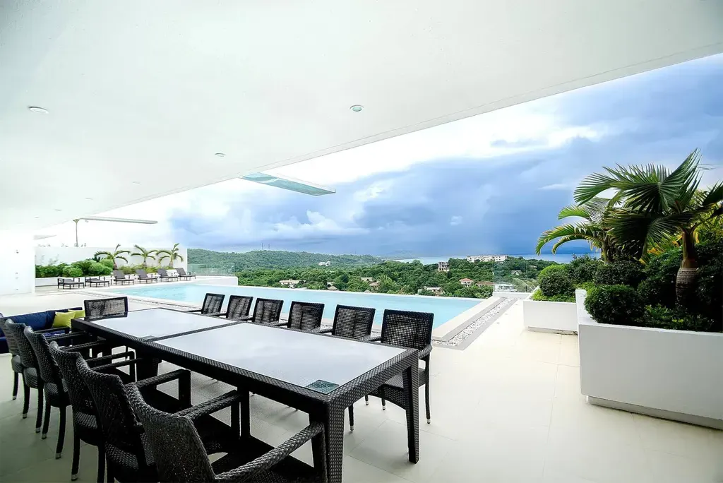 Outdoor dining table beside the infinity pool with sea view